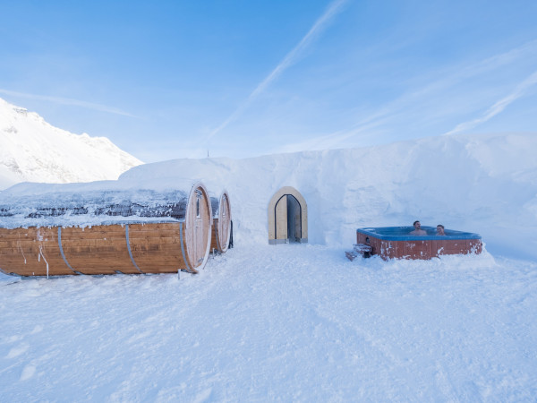 Whirlpool und Fasssauna, dahinter Eingang zum Iglu-Dorf